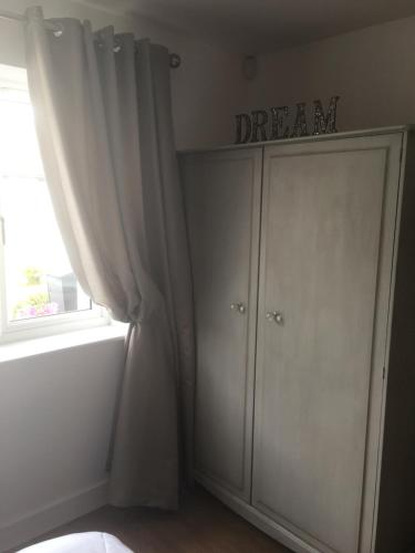 a white cabinet with a dream sign on it next to a window at Hedlea in Redruth