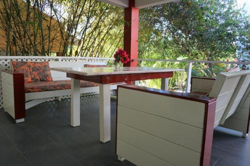a table and a bench on a porch with a table at Don Genaro Apartments in Barber