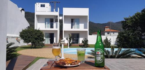een tafel met een bord eten en een fles bier bij Quinta do Lapa in Florianópolis