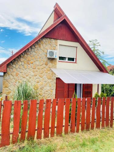 a house with a red fence in front of it at Violet Holiday’s House in Siófok