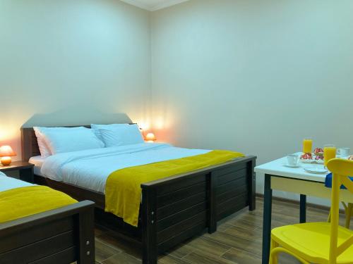 a bedroom with a bed with a yellow blanket on it at Borjomi Yellow Hotel in Borjomi