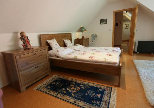 a bedroom with a bed and a dresser and a rug at EHM Family Resort in Mesteri