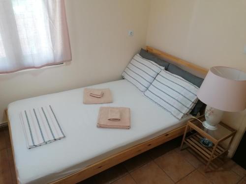 a bed with two towels on it with a lamp at The Lake House -Trichonida Lake in Marathiás