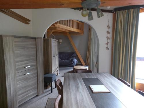 une salle à manger avec une grande table en bois et une chambre dans l'établissement 2 Pièces à 20m des Pistes avec Parking à Tignes - FR-1-449-65, à Tignes