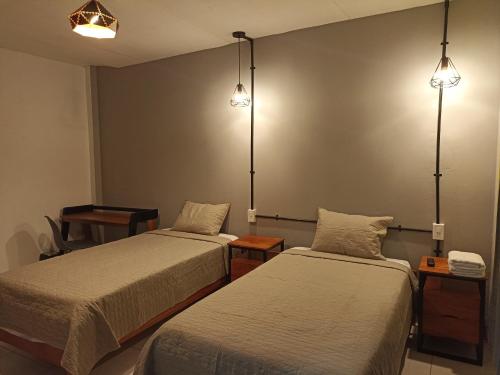 a room with two beds and two lights on the wall at Bijao Hostel in Tarapoto