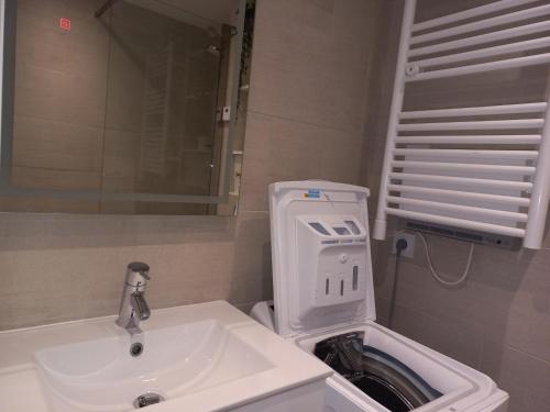 La salle de bains est pourvue d'un lavabo blanc et d'un miroir. dans l'établissement Studio Tignes, 1 pièce, 4 personnes - FR-1-449-72, à Tignes