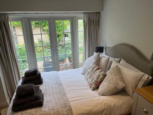 1 dormitorio con cama con almohadas y ventanas en Annex Fishers Yard, en York