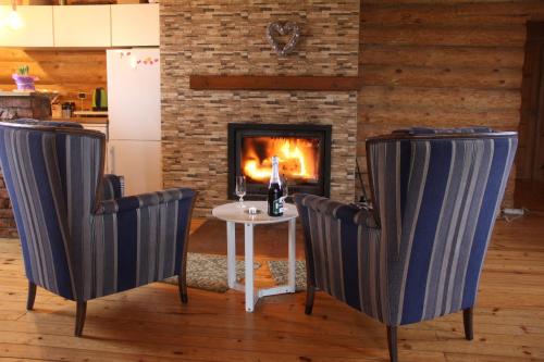 a table and two chairs in front of a fireplace at Zaķu muiža in Anspoki