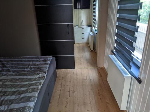 a bedroom with a bed and a wooden floor at Haus Karl in Ueckermünde