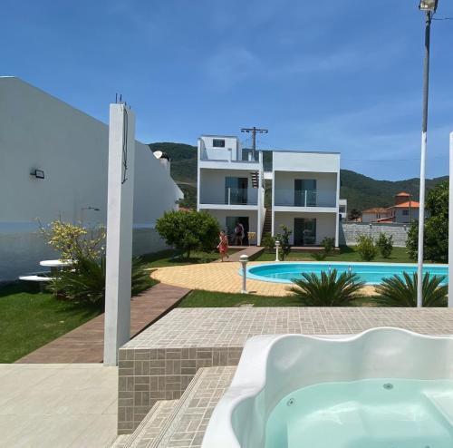 een villa met een jacuzzi en een zwembad bij Quinta do Lapa in Florianópolis