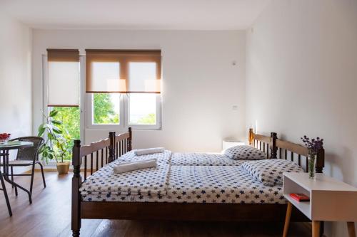 a bedroom with two beds and a table and chairs at Vila Peristeron in Golubac