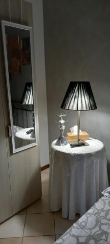 a table with a lamp on it next to a mirror at La casa di Ada in Sondrio