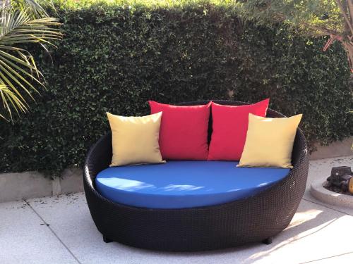 a wicker chair with colorful pillows on a patio at My PoolVilla Cha am in Cha Am