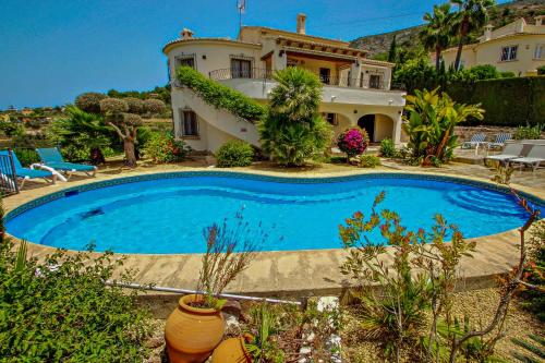 a swimming pool in front of a house at Nessa - well furnished villa with panoramic views in Benitachell in Benitachell