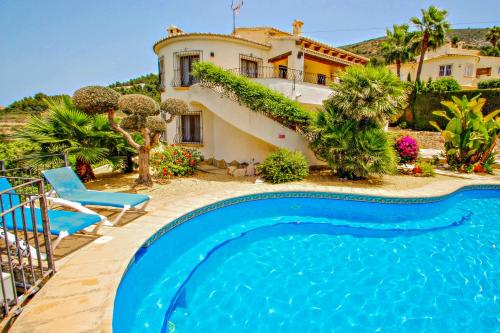 a villa with a swimming pool in front of a house at Nessa - well furnished villa with panoramic views in Benitachell in Benitachell