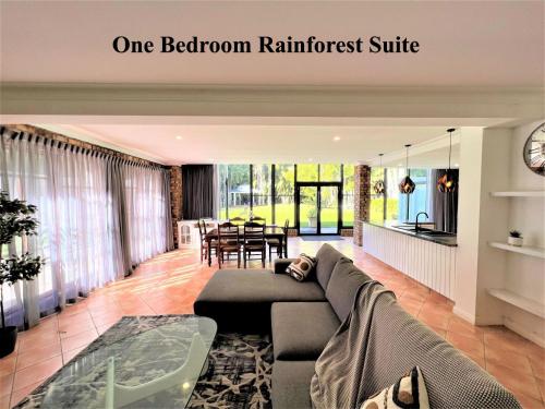- un salon avec un canapé et une salle à manger dans l'établissement Mt Tamborine Stonehaven Boutique Hotel, à Mount Tamborine