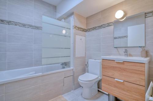 uma casa de banho com um WC, um lavatório e uma banheira em Logement Elia em Courcouronnes