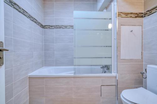 a bathroom with a tub and a toilet at Logement Elia in Evry-Courcouronnes