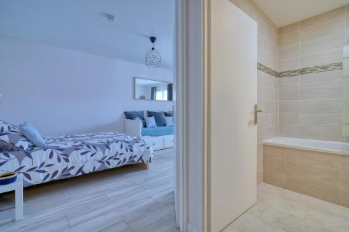 a bedroom with a bed and a bath tub next to a bathroom at Logement Elia in Evry-Courcouronnes