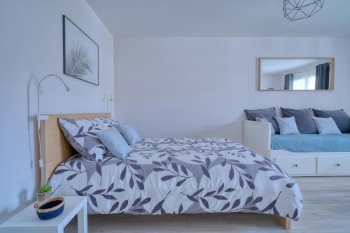 a bedroom with a bed with a blue and white comforter at Logement Elia in Evry-Courcouronnes