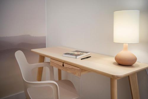 a wooden desk with a lamp and a chair at Magnifique appartement plein centre, calme, Netflix in Mirepoix