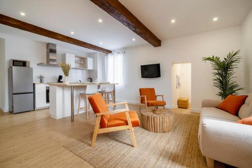 a living room with a couch and a table and a kitchen at Magnifique appartement plein centre, calme, Netflix in Mirepoix