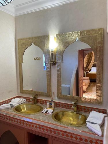 a bathroom with two sinks and a large mirror at Riad Ksar Al Amal & Spa in Marrakech