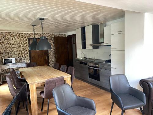 a kitchen and dining room with a wooden table and chairs at Molltaler Appartements en b&b in Stall