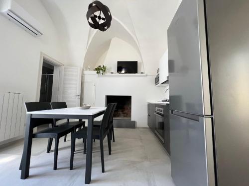 una cucina con tavolo, sedie e frigorifero di Le dimore del salento appartamento 2 a Tricase