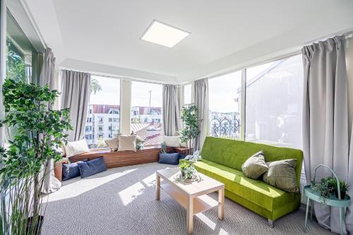 a living room with a green couch and large windows at The house Kaunas in Kaunas