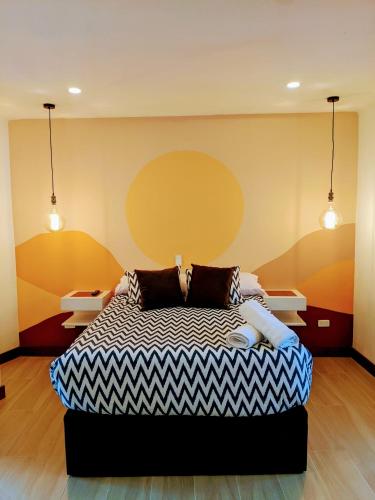 a bedroom with a bed and two lights on the wall at OFF HOSTEL in Villa de Leyva