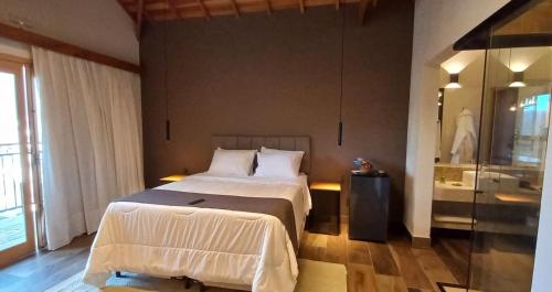 a bedroom with a large bed and a window at Terrace Chalés in Monte Verde