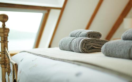 a pile of towels sitting on top of a bed at Hawthorn Cottage in Uig