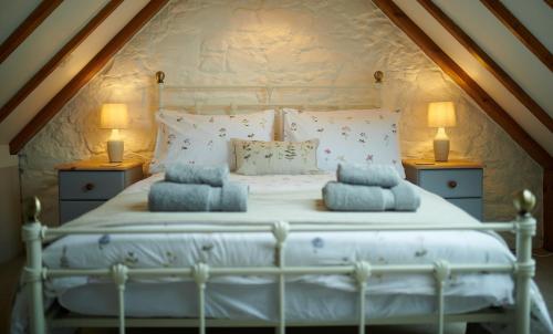 a bedroom with a white bed with two lamps at Hawthorn Cottage in Uig