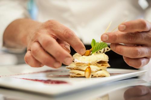 a person eating a dessert on a plate at Boutique & Gourmet Hotel Orso Grigio in San Candido