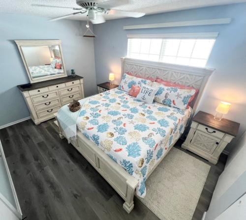 a bedroom with a bed and a mirror at Beachfront Serenity Private Balcony with Ocean View, Shared Heated Pool and BBQ in New Smyrna Beach