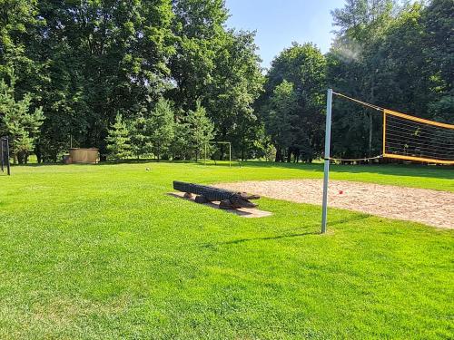 a group of benches in a field with a soccer goal at Atostogų namelis-pirtis Prie upės in Anykščiai