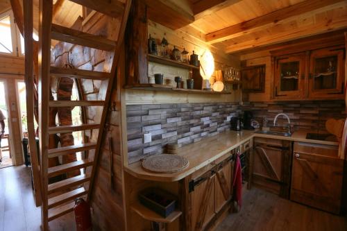 uma cozinha com paredes de madeira e uma escada num camarote em EHM Baumhaus Chalet em Mesteri