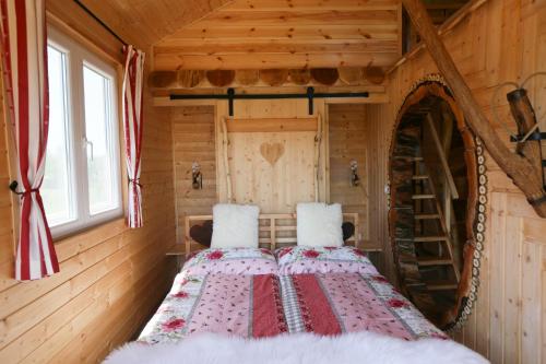 um quarto com uma cama num chalé de madeira em EHM Baumhaus Chalet em Mesteri
