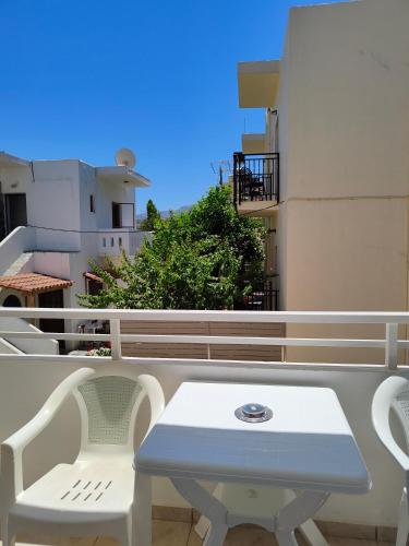 a white table and chairs on a balcony at Sofia Studios & Apartments in Georgioupolis