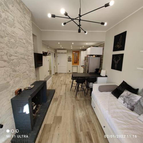 a living room with a white couch and a fireplace at Casa di Nastya in Pretoro