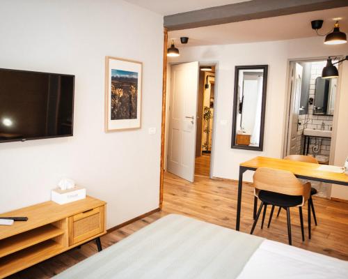 a bedroom with a desk and a tv on a wall at CASA HINTZ Transilvania in Făgăraş