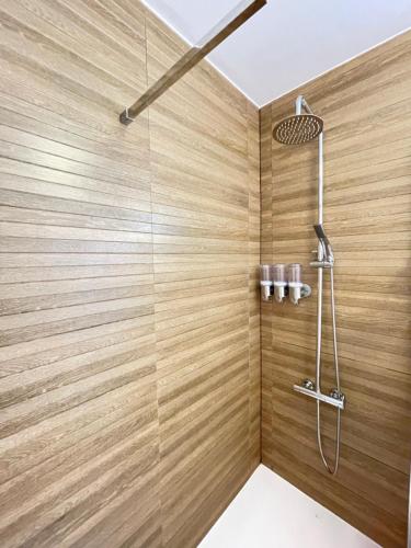 y baño con ducha y paredes de madera. en AGPI Fuerteventura Apartments Internet Fibra WIFI GRATIS, en Costa Calma
