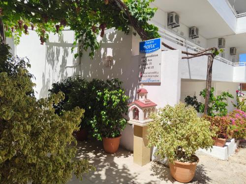 a building with potted plants and a bird house at Sofia Studios & Apartments in Georgioupolis