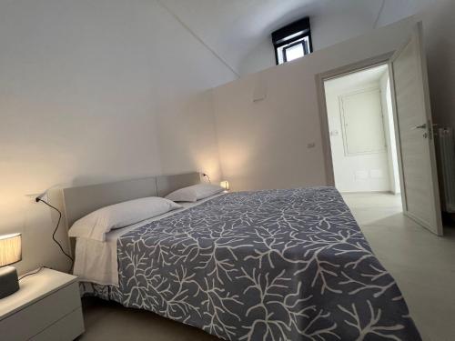 una camera con un letto con una coperta bianca e nera di Le dimore del salento appartamento 2 a Tricase