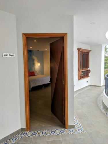 a door into a room with a bed in the background at OFF HOSTEL in Villa de Leyva