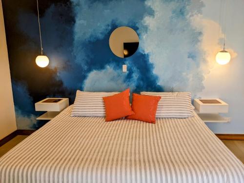a bedroom with a bed with orange pillows at OFF HOSTEL in Villa de Leyva