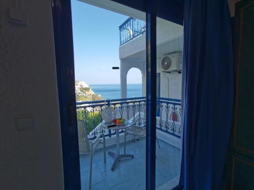 a balcony with a table and a view of the ocean at Marinas Studios in Livadia