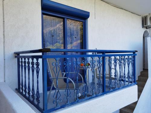 a blue railing on a balcony with a window at Marinas Studios in Livadia