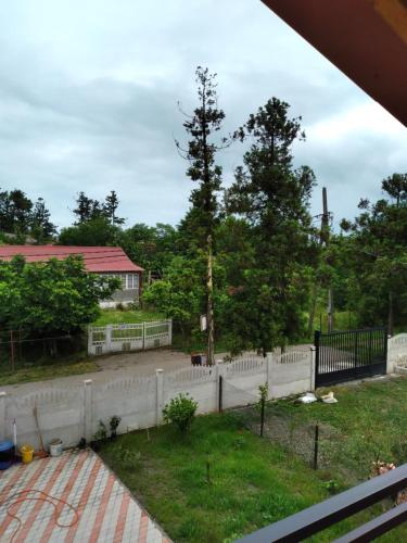 a fence in front of a yard with trees at Апарт-отель "У речки" in Kuchkisabano